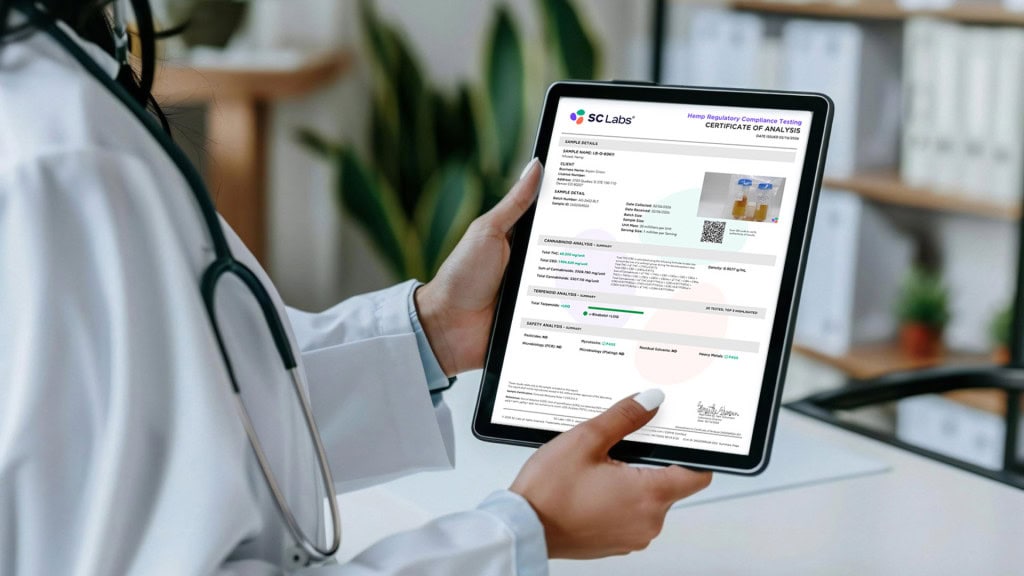 Healthcare professional holding a Certificate of Analysis (COA) while displaying CBD products used to explain laboratory testing and product transparency.