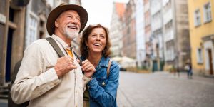 A man and woman smile as they look down the road at their vacation destination.