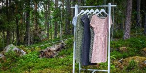 Sustainable women's apparel hanging on a rack in the woods