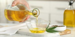 Woman pouring cannabis oil into a glass bowl for cooking