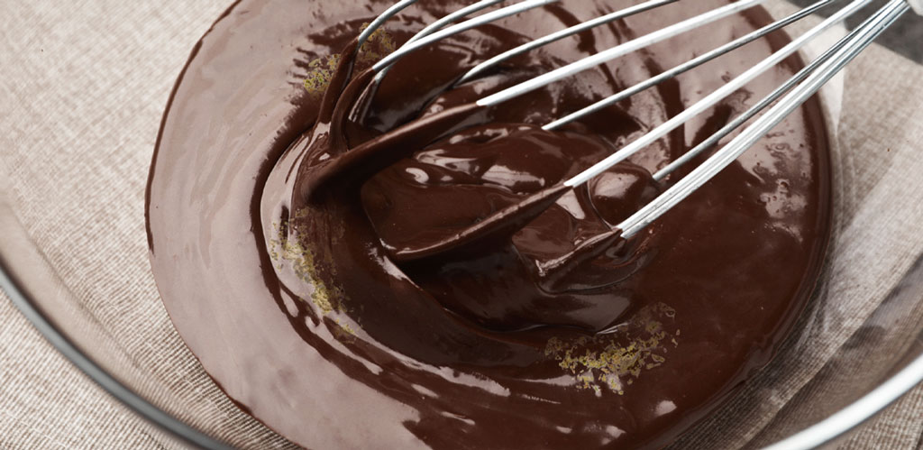 Cannabis flower, chocolate pieces, butter, and sugar cubes arranged on a wooden board for edible preparation