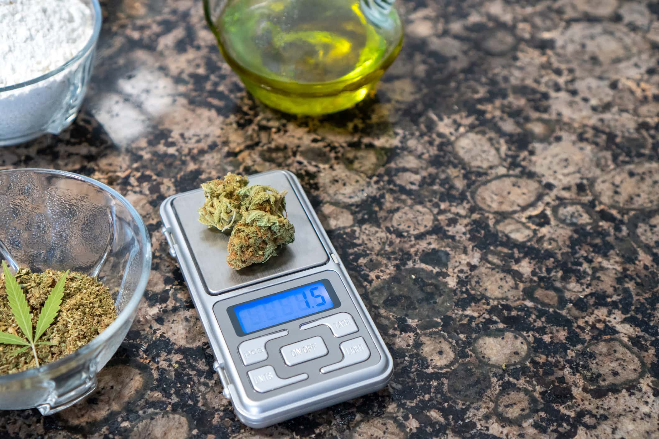 cannabis flower being weighed on digital scale for oil infusion