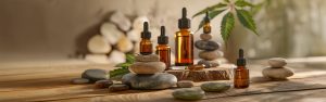 CBD oil on a wooden table with stones scattered around