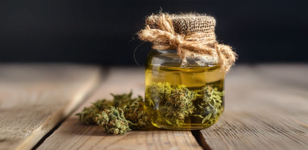 Mason jar with hemp infused oil over a wooden table