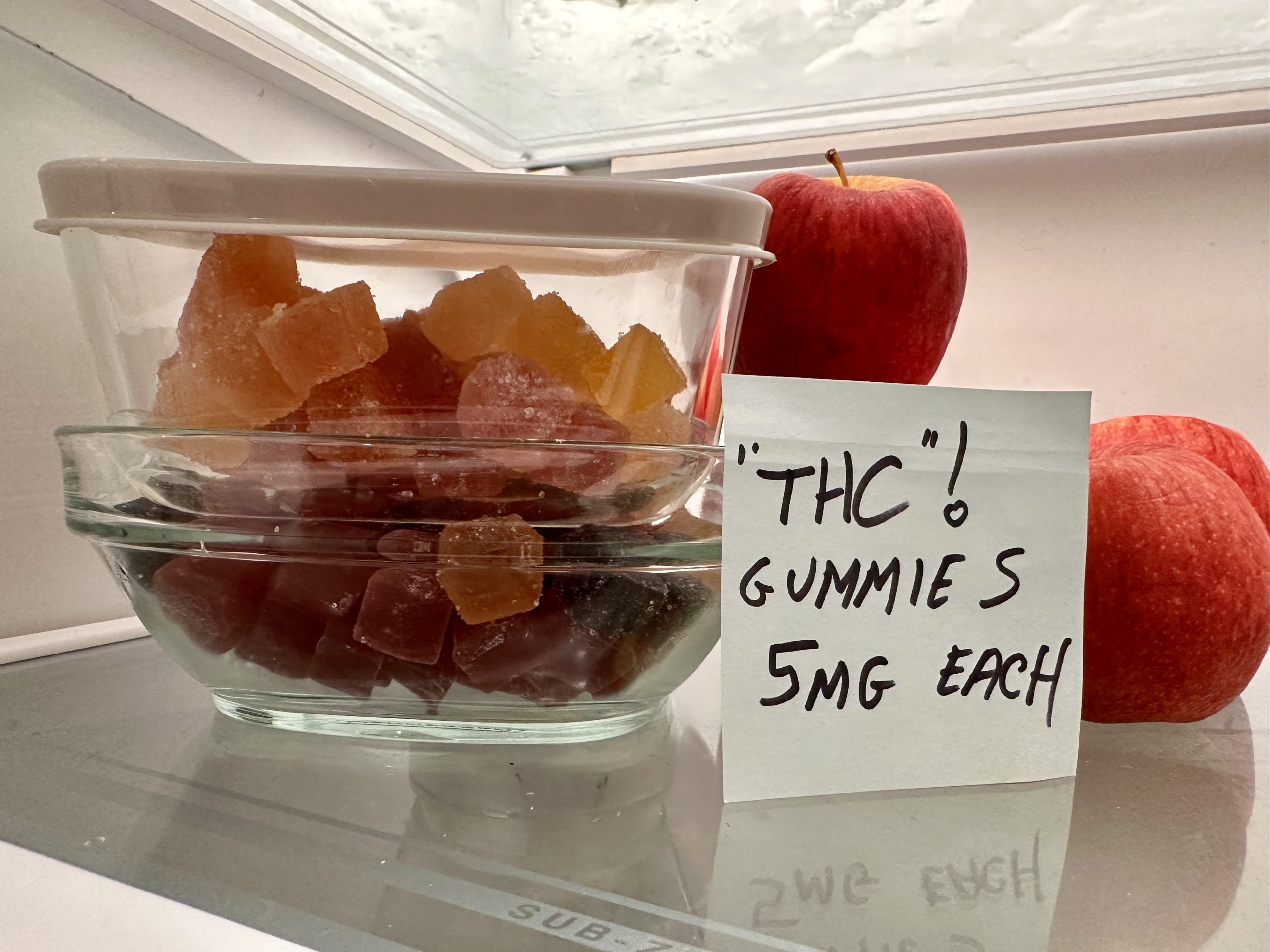 Storing homemade THC gummies in an airtight container in the refrigerator.
