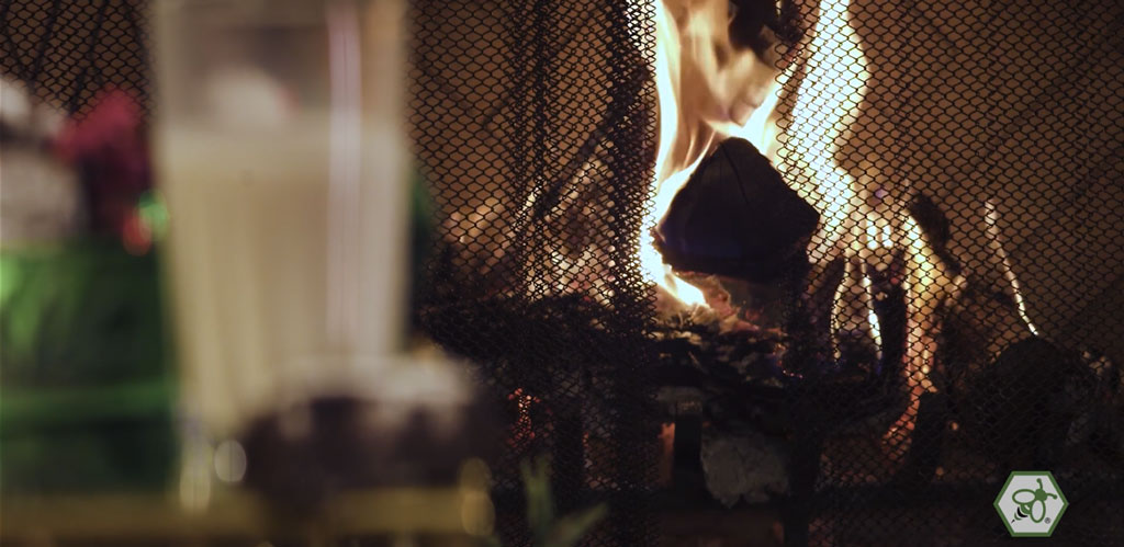 Fire burning in a fireplace behind a mesh screen, creating a calm, intimate holiday atmosphere