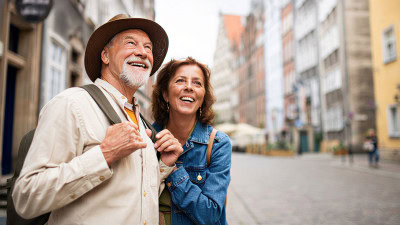 Smiling couple enjoying a city vacation after planning ahead for responsible cannabis travel.